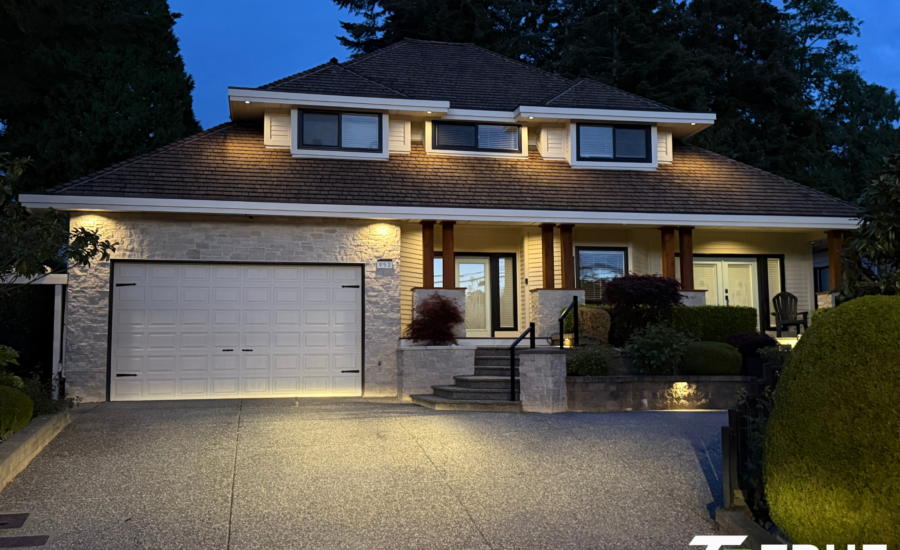 Modern house in the King George Corridor of South Surrey illuminated at night by custom exterior soffit lighting.