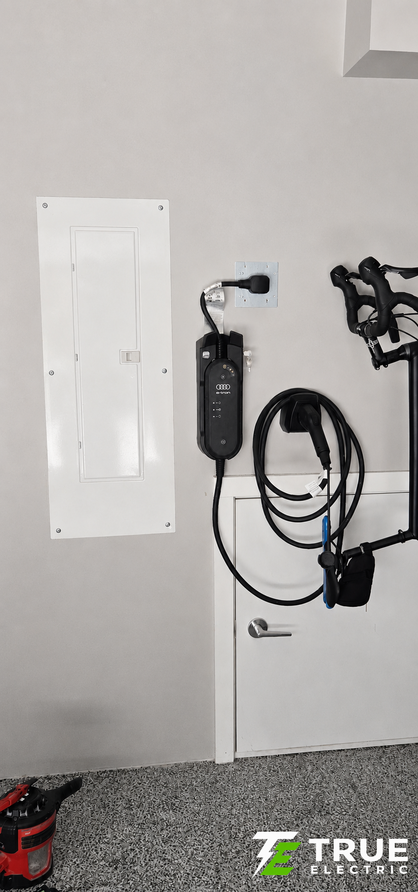 A single Level 2 smart EV charger mounted on a residential garage wall in South Surrey