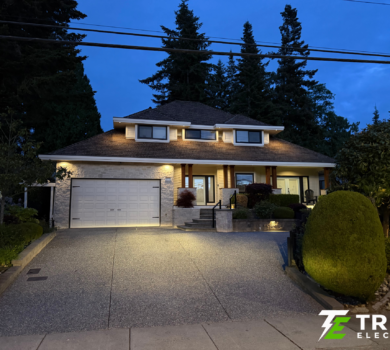 Modern house in the King George Corridor of South Surrey illuminated at night by custom exterior soffit lighting.