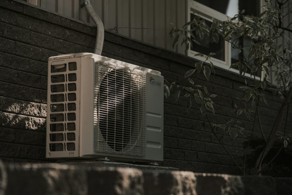 An outdoor heat pump unit completely installed and wired with a weatherproof safety disconnect switch by a licensed team member