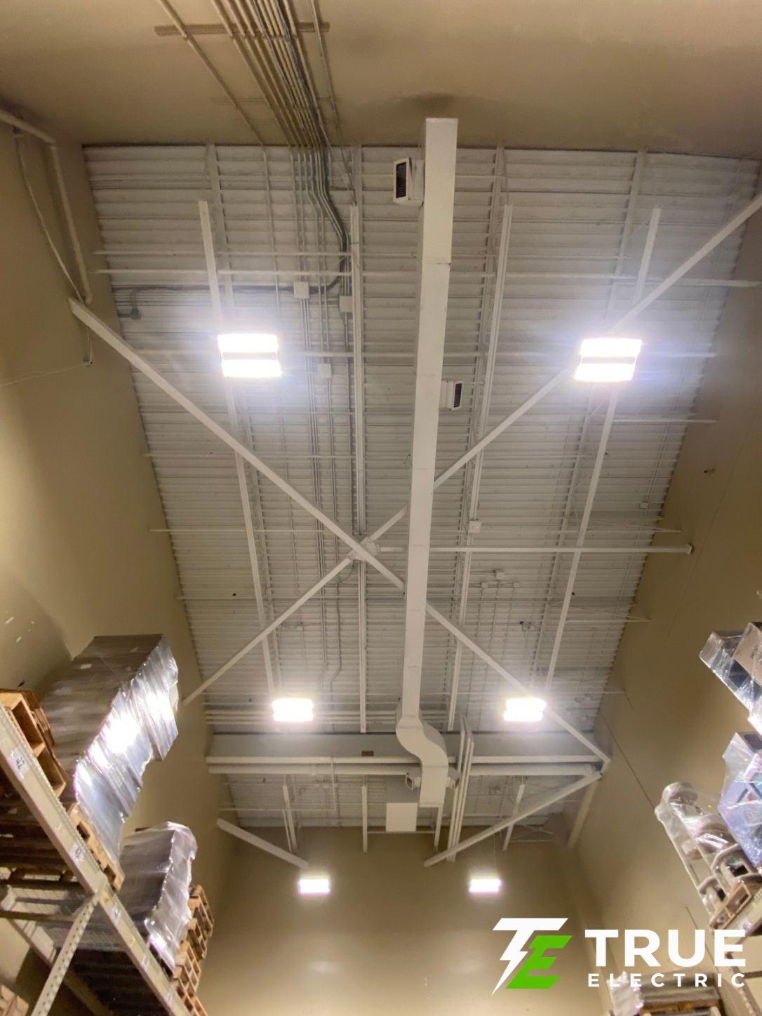 Overhead commercial storage racks brightly illuminated by new energy-efficient industrial high bay LED lights eligible for BC Hydro rebates.